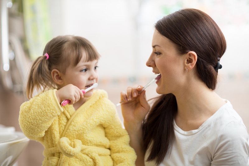 Mom and daughter brushing teeth